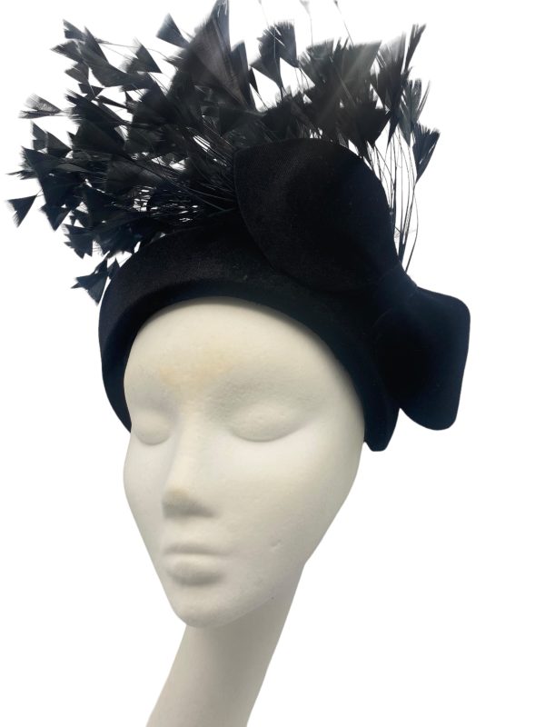 Black velvet crown with a spray of feather detail.
